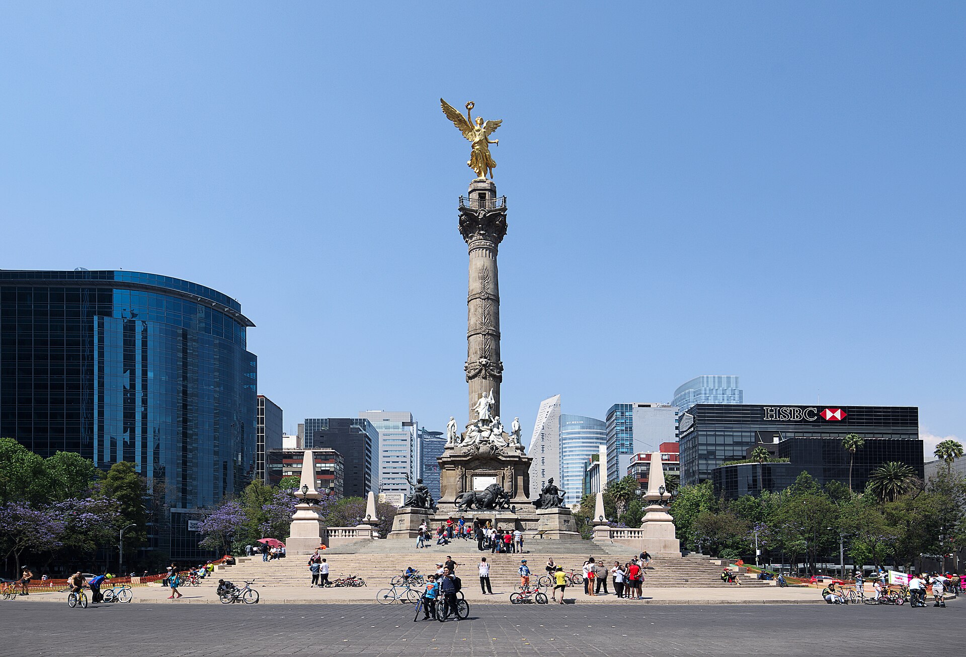 The gilded Angel of Independence monument on Paseo de la Reforma in Mexico City with office towers behind