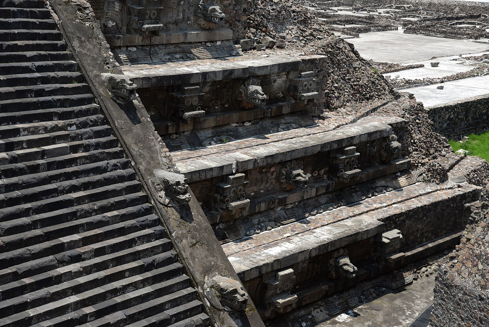 Carved stone feathered serpent heads and Tlaloc masks projecting from the tiered facade of the Temple of Quetzalcoatl at Teotihuacan