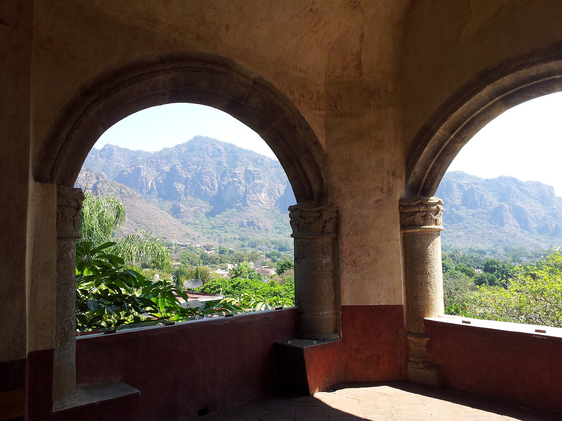 The cliffs of the Tepozteco seen through the stone arches of the arcade at the Ex-Convento de la Natividad in Tepoztlán